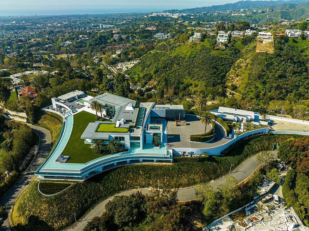 Aerial view of The One mansion in Bel-Air, a long modern white house with lawns on a hilltop above Los Angeles